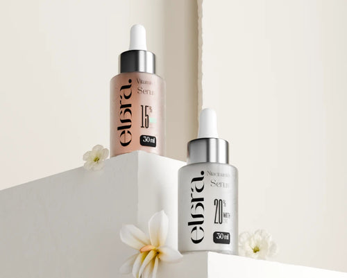 Two skincare serum bottles with droppers on a light background